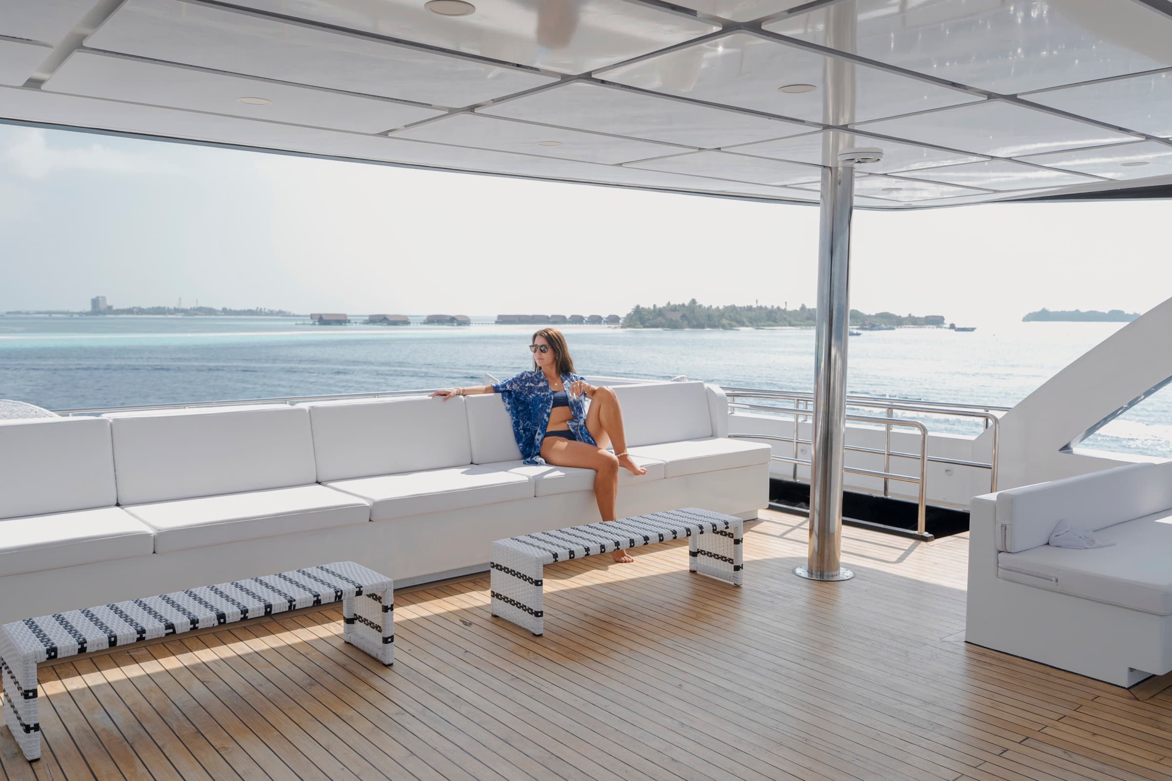 Guest relaxing on the SERAI Ocean Dream sundeck with Maldives islands in the background